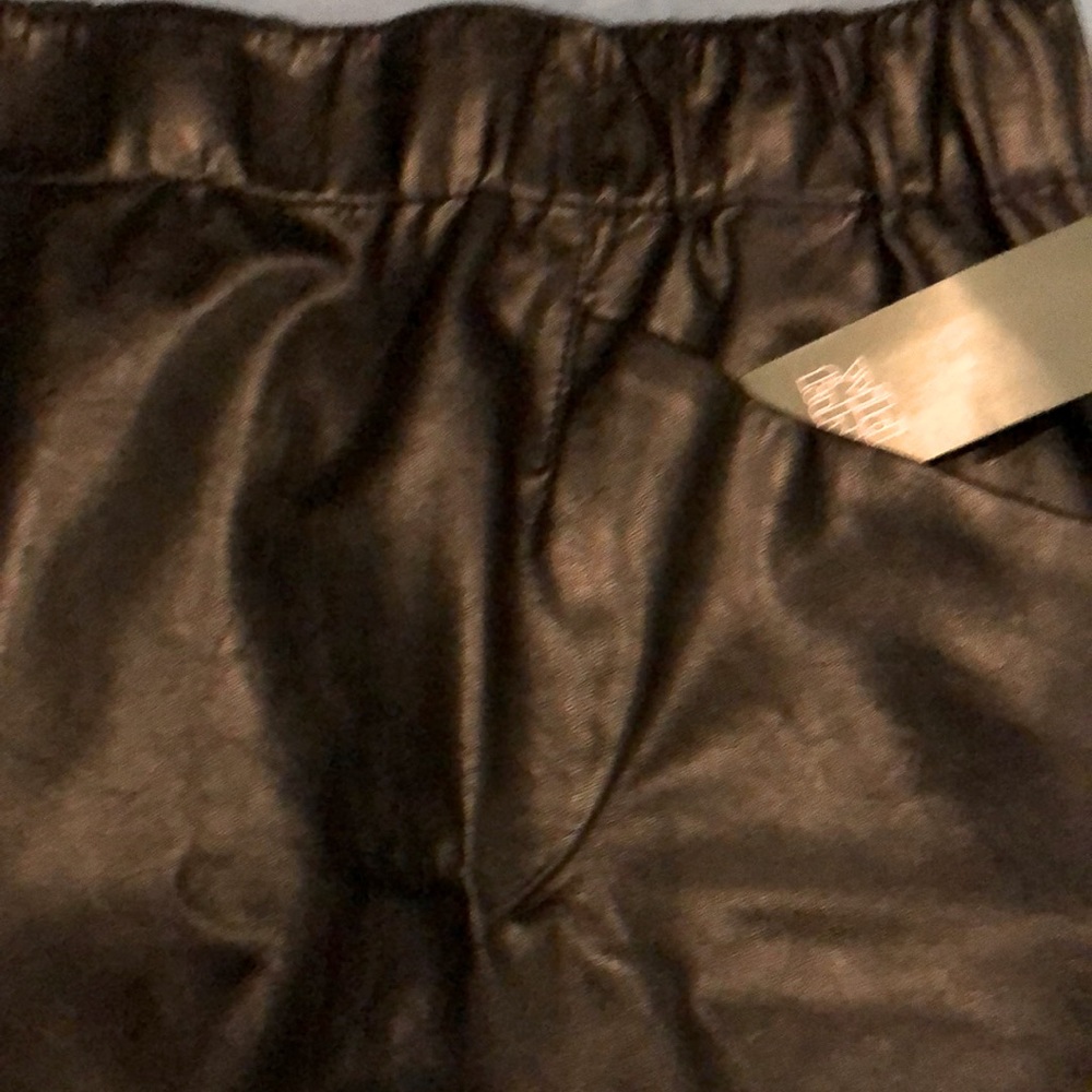 NWT black mini skirt looks like leather, but not.Elastic waist w/2 front pockets